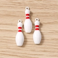 Détail de trois pendentifs de bowling blancs avec bandes rouges pour la création de bijoux - Quille de Bowling / Lot de 10 / Rouge