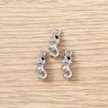 Detailed view of three silver seahorse metal charms with black eyes on wood background - Silver Seahorse