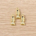Detail of three golden fish pendants with black rhinestone eyes on wooden background - Gold Goldfish