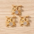 Vista macro di tre ciondoli a forma di batteria dorata con strass su legno - Confezione da 10 / Oro