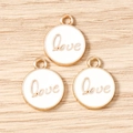 Detailed view of three white enamel Love pendants with gold borders for DIY jewelry making - LOVE Letter Round Tag (3206) / 10 Pieces Pack / White