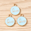 Macro shot of three round light blue enamel Love pendants with gold plating for DIY jewelry - LOVE Letter Round Tag (3206) / 10 Pieces Pack / Blue