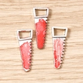 Detailed macro view of three silver alloy bloody saw pendants for DIY Halloween jewelry - 10 Pieces Pack / Saw Shaped