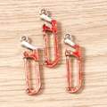 Macro shot of silver metal saw pendants with bloody red splatters on wood background - 10 Pieces Pack / Small Saw Style