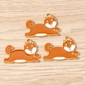 Detailed view of three cute orange shiba inu enamel charms on a rustic wooden background - 10 Pieces Pack / Shiba Inu