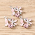 Dettaglio macro di ciondoli a fiore e farfalla con cristalli e smalto per gioielli fai-da-te - Farfalla di Fiori / Confezione da 10 / Rosa Argento