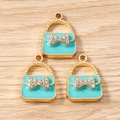 Detail of light blue handbag charms with gold base, crystal bow and enamel finish - Green