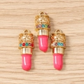 Macro-opname van drie gouden lippenstift bedeltjes met kleurrijke kristallen en email - 10 Stuks Verpakking / Rozerood