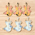Detailed macro view of violin shaped enamel alloy charms with floral patterns and loops - 10 Pieces Pack / Multicolor Cello