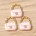 Close-up of three pink enamel handbag charms with gold chain handles for DIY jewelry making - 10 Pieces Pack / Pink