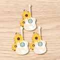 Detail of three white enamel guitar pendants with yellow sunflowers and musical notes - 10 Pieces Pack / Yellow Sunflower Guitar