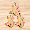 Macro detail of three violin-shaped enamel charms with pink cherry blossom accents - 10 Pieces Pack / Orange Cello
