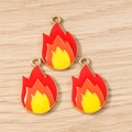 Detailed view of three fire flame pendants with red orange yellow enamel and gold trim - Flame / 10 Pieces Pack