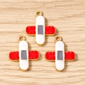 Three cross-shaped alloy enamel pendants on wood background for DIY jewelry making - White