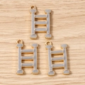 Close-up of three golden H-shaped charms with grey enamel inlay on a wood surface - Ladder (Step H-Shaped Design)