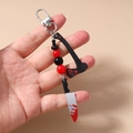 Hand holding Halloween beaded keychain with blood-stained axe and cleaver charms - Bloody Knife And Axe Style