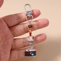 Macro-opname van een miniatuur camera hanger met gemengde decoratieve kralen aan koord - Camera Kralen Sleutelhanger