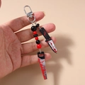 Detail of Halloween beaded keychain with blood-splatter effect knife and saw charms - Bloody Saw Style