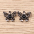 Detaillierte Makroansicht schwarzer Schmetterlingsanhänger mit Herzsteinen für DIY-Schmuck - Grauschwarz