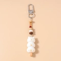 Close-up of beaded keychain featuring three cute white cat dumpling charms and colorful beads - Beaded Emoji Dango