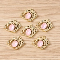 Dettaglio di ciondoli a stella e luna dorati con pietre rosa e strass bianchi lucidi - Gemma Occhio del Diavolo Rosa