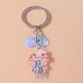 Dettaglio di un portachiavi a forma di medusa rosa in resina con glitter e conchiglie blu - Medusa