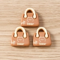 Detail of three resin bear handbag charms in caramel brown for DIY jewelry making - 10 Pieces Pack / Handbag Shape (Caramel Brown)