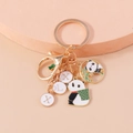 Goldener Panda Schlüsselanhänger mit Bambus Anhänger und Buchstaben Tags auf Rosa - Panda