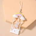 Macro shot of beaded phone strap with rainbow, cloud, and glittery bear charms - White