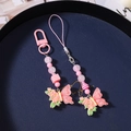Dettaglio di ciondolo a farfalla rosa e perline di fiori con anello a D e laccetto - Rosa