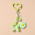 Détail d'un porte-clés vert avec fleur de marguerite, papillon en résine et perles - Papillon Vert