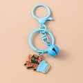 Detailed view of sky blue cat keychain with black enamel kitten and red coral branch pendant - Red and Blue Cats