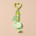 Close-up of green beaded keychain with transparent bear charm and Good Luck tag - Good Luck (1906) / Green