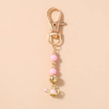 Vue détaillée d'un porte-clés perlé rose avec breloque arrosoir doré et cœur - Porte-clés Arrosoir Perles Or