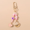 Dettaglio del portachiavi con perline, conchiglie rosa, cuore viola e gancio dorato - Rosa