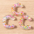 Close-up of colorful resin letter C pendants with glitter sequins for DIY jewelry - Letter C