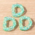 Detailed macro view of mint green resin letter D charms with iridescent mosaic glitter finish - Letter D