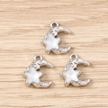 Detalle de dijes de estrella y luna plateados con textura lunar e incrustación de opalo - Plata