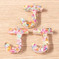 Close-up of three J-shaped colorful resin alphabet charms with iridescent sequins and rings - 5 Pieces / Letter J
