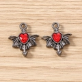 Detailed view of Gothic bat wing heart pendants with red faceted gems and cupid arrows - 5 Pieces / Grey Red