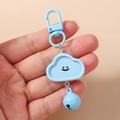 Porte-clés nuage bleu avec visage souriant et clochette assortie dans la main - Forme de nuage / Bleu