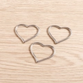 Tre ciondoli a cuore d'argento su legno chiaro per la creazione di gioielli fai-da-te - Bianco K/Argento