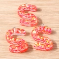 Detailed macro view of S-shaped resin letter pendants with vibrant pink orange glitter - 5 Pieces / S