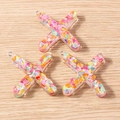 Close-up of X-shaped colorful resin letter charms with iridescent glitter and metal loops - 5 Pieces / Letter X