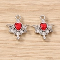 Detailed close-up of gothic silver bat wing charms with red heart jewels for DIY jewelry - 5 Pieces / Silver Red