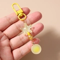 Détail du porte-clés à perles jaunes avec étoile de mer et pendentif boule dépolie - Jaune