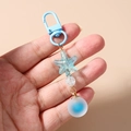 Détail d'un porte-clés perles océan avec étoile de mer et boule bleu givré en dégradé - Bleu