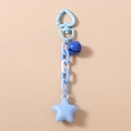 Détail du fermoir cœur bleu avec chaîne, pendentif étoile et clochette sur le porte-clés - Bleu