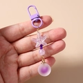 Détail d'un porte-clés à perles mauves avec breloque étoile de mer et sphère mate sur clip - Violet