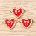 Detail von roten Herzanhängern mit goldener Schleife und Zirkoniasteinen für DIY Schmuck - 10er Pack / Gold Rot